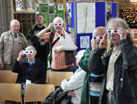 Priory exhibitions: people watching 3d slideshow of 2016 MSA well dressings, (note the 3D glasses).